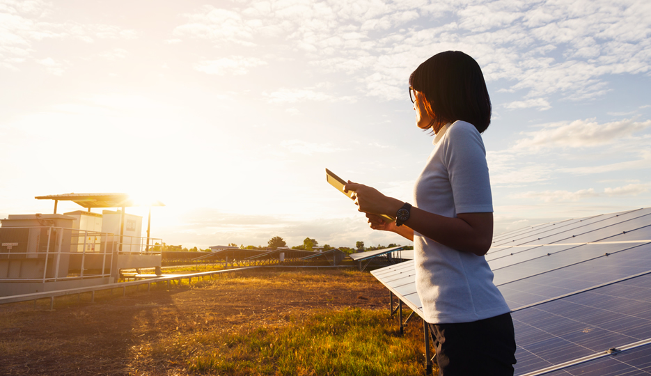 Woman Holding iPad Outside Sun Solar Panels